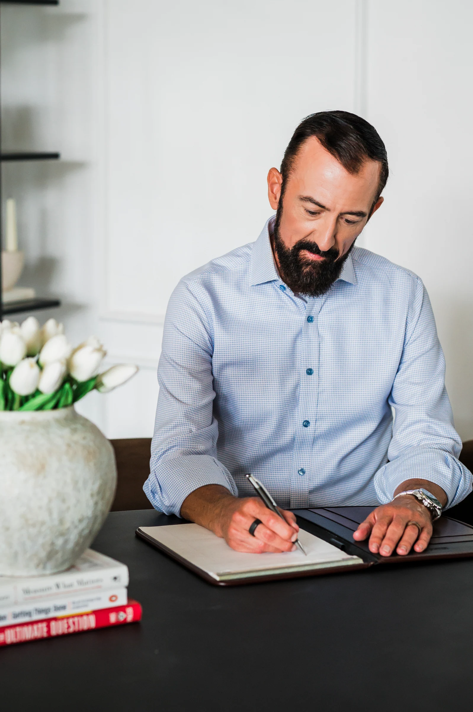 Raymond writing in a notebook at his desk